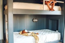 a modern kids’ room with built-in bunk beds, neutral bedding, baskets and lights and lamps is a dreamy and chic space