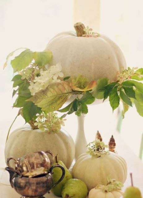 a natural pumpkins with fall foliage and white blooms, with white pumpkins and pears makes up a cool fall centerpiece