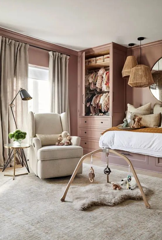 a pink kid's room with a raised bed, a mobile and a chair, some pendant lamps is a chic place