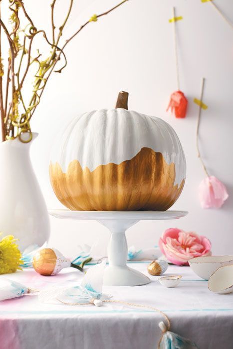 a pretty white and gold pumpkin on a stand is a cool centerpiece in modern style or just decoration
