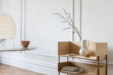 a serene white space with molding on the walls, light-stained furniture, a parquet floor and some dreamy decor