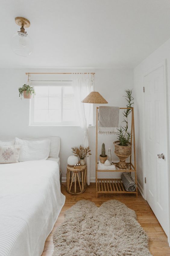 a small bedroom done in a neutral and warm color scheme to make it larger and filled with light