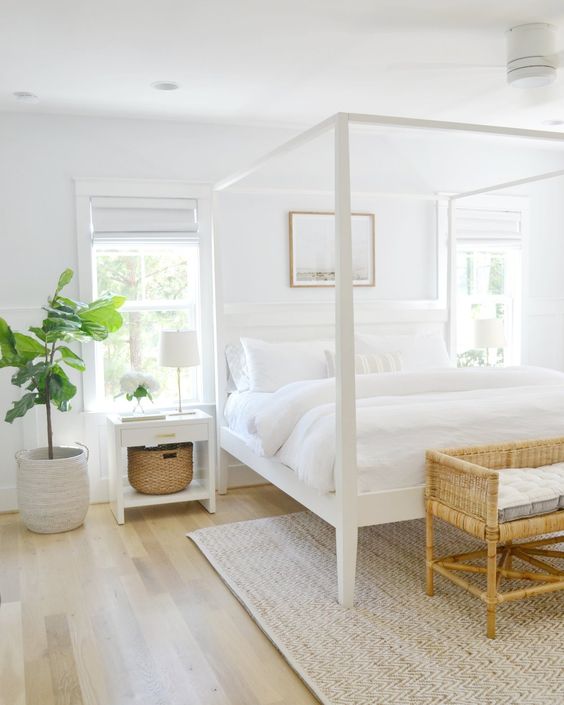 a small bedroom looks bigger thanks to the neutral color scheme and two windows that fill the room with light