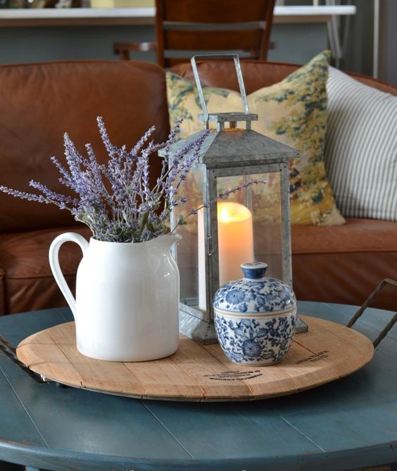 a wooden tray with a vintage candle lantern, a white jug with lavender and a blue patterned sugar pot for small stuff