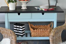 an IKEA Forhoja cart hacked with blue paint and with a chalkboard countertop is used for storage in the kitchen