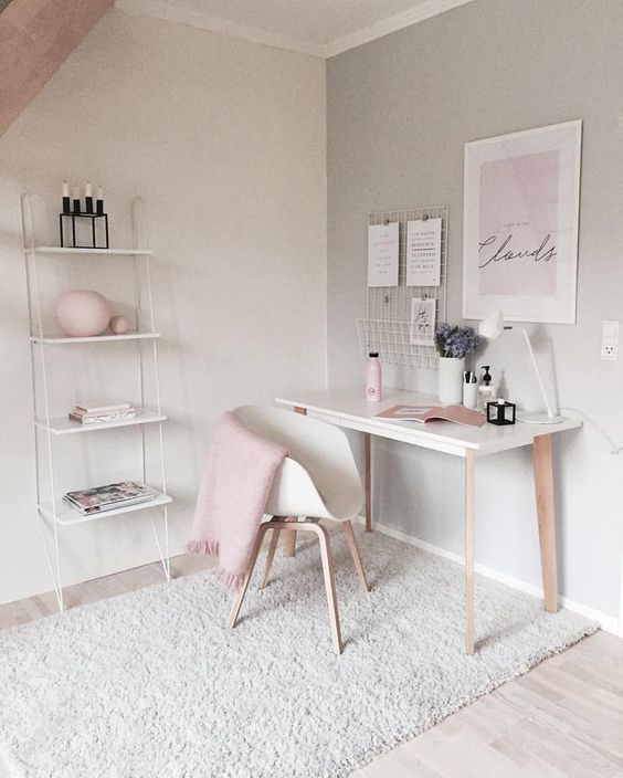 an airy Scandinavian workspace with dove grey walls, a lightweight desk and a white chair, pink decor and details