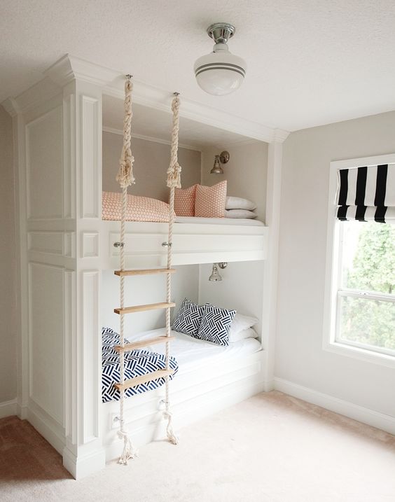 built-in bunk beds with a rope ladder hanging from the ceiling make up a cozy and cute space for sleeping