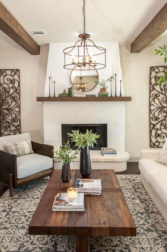 some books, a candle and blakc vases with greenery for a stylish laconic touch