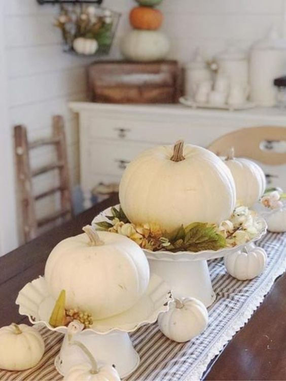 white pumpkins with fall leaves and berries plus some white pumpkins on the table for a centerpiece