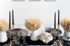 a bold Thanksgiving tablescape with a black runner and plates, black candles, wheat in jugs is very elegant