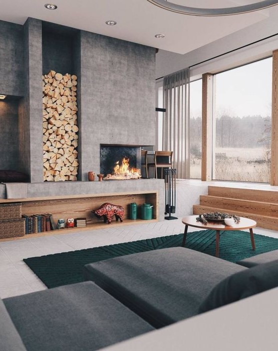 a bold and cool modern living room with a large concrete fireplace and a niche for storing firewood is very welcoming