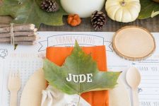 a bright and simple Thanksgiving table with fall leaves, berries, pumpkins, pillar candles and touches of orange
