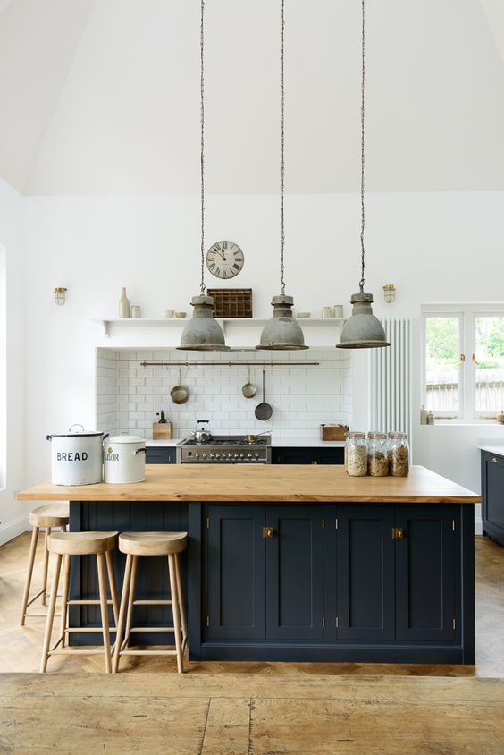 a chic traditional kitchen with black shaker style cabinets, a large kitchen island with storage and a seating zone around the corner