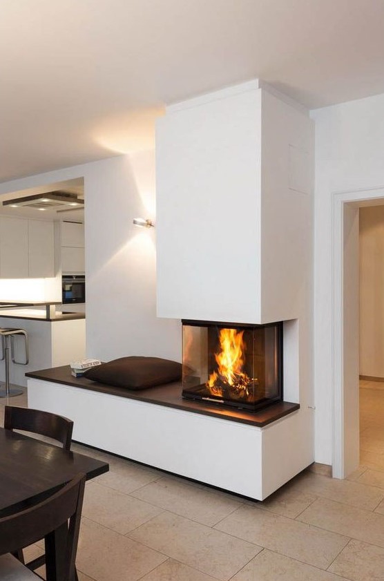 a contemporary fireplace with a bench to enjoy it and a glass cover to make the fire all-visible