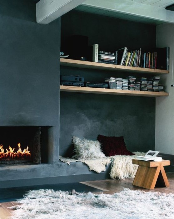a contemporary space with a built-in fireplace with a screen and a bench with pillows built-in next to the fireplace