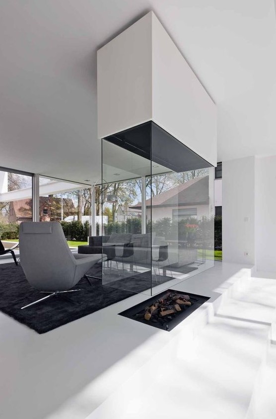 a contemproary fireplace built into the floor, with a white hood and a glass cover is a stylish idea to go for