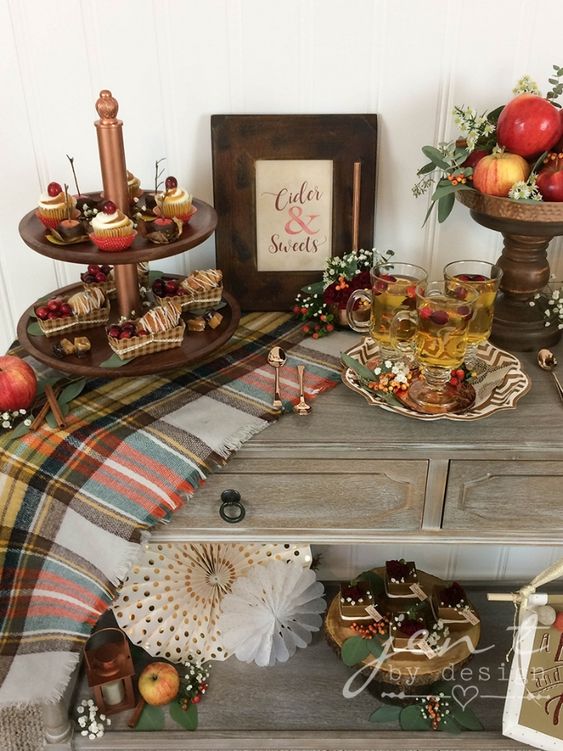 a cool Thanksgiving sweets table with a plaid runner, bold apples and greenery, berries and blooms is a stylish idea for the fall