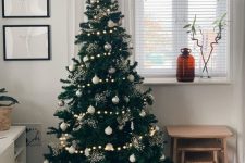 a gorgeous modern Christmas tree with lights, white and silver ornaments, shiny sparkles is a lovely idea for your modern space