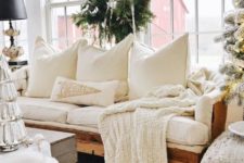 a knit blanket and lots of pillows plus a jute rug make the living room welcoming and cozy