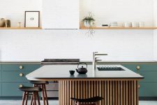 a lovely modern kitchen with green lower cabinets and an open shelf over them, a chic kitchen island with wooden slabs and a stone countertop, tall stools