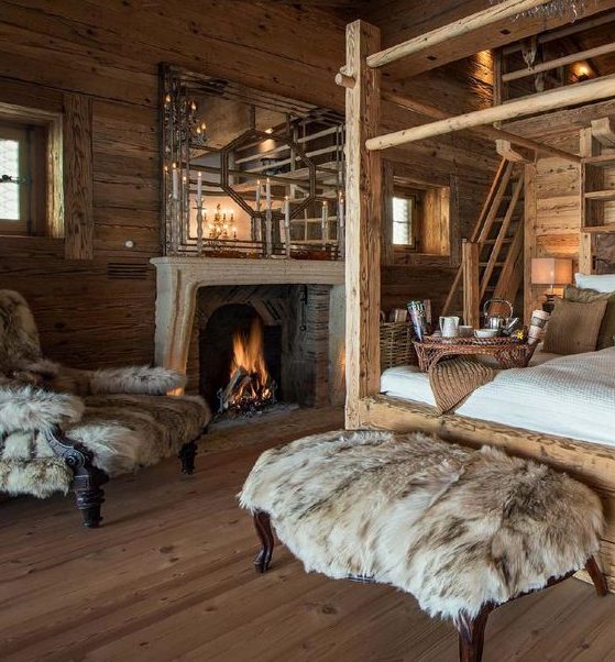 a luxurious chalet bedroom all clad with wood, with a canopy bed, a fireplace, a large mirror, faux fur covered furniture
