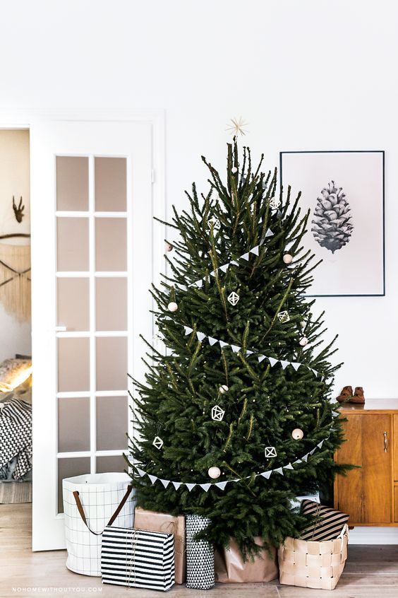 a minimalist Scandinavian Christmas tree with white buntings, lights and just several white ornaments is all you need as less is more