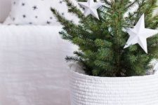 a modern Christmas tree in a tall woven basket, with oversized white stars is a gorgeous idea for your neutral space