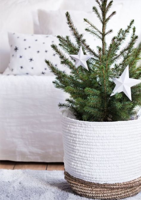 a modern Christmas tree in a tall woven basket, with oversized white stars is a gorgeous idea for your neutral space