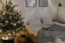 a modern Christmas tree with black, white and silver ornaments, with lights in a black bucket with lights is a cool idea