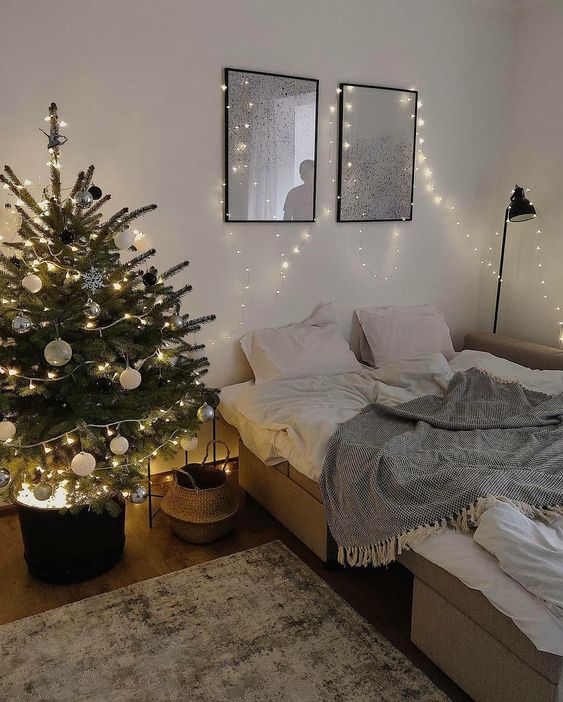 a modern Christmas tree with black, white and silver ornaments, with lights in a black bucket with lights is a cool idea