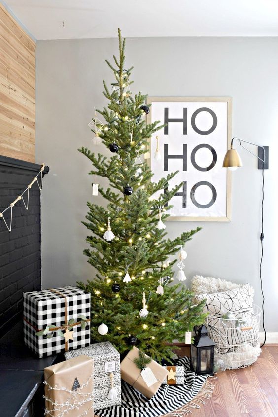 a modern Christmas tree with white and black ornaments and lights is a stylish idea that will fit a Scandinavian space, too