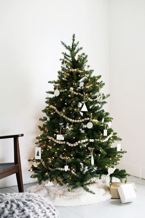 a modern Nordic Christmas tree with lights, wooden beads, white clay ornaments and baubles is a stylish idea