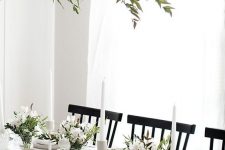 a modern and very neutral Thanksgiving tablescape with neutral porcelain and linens, greenery and white blooms plus white candles