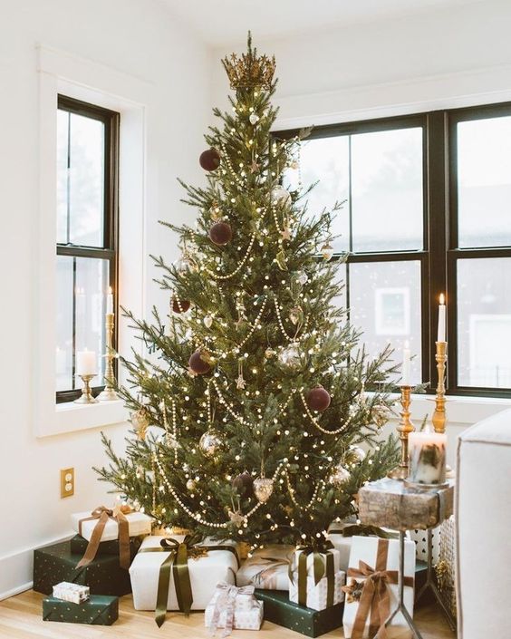 a modern glam Christmas tree with beads, silver and chocolate brown ornaments and lots of lights plus a crown tree topper