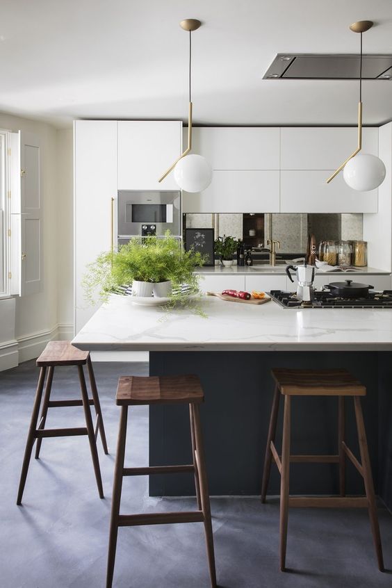 a modern kitchen with sleek white cabinets, a graphite grey kitchen island with a marble countertop, dark stained stools and pendant lamps