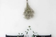 a modern to minimalist Thanksgiving tablescape with grey and black pumpkins, greenery and neutral linens is laconic and stylish