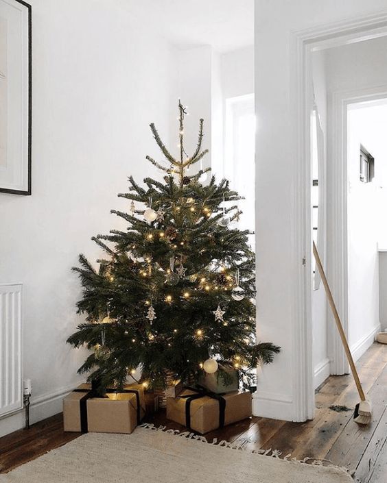 a pretty modern Christmas tree with white, silver and clear ornaments, pinecones and lights is amazing and fresh