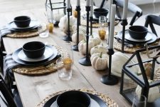 a stylish modenr farmhouse tablescape with woven chargers, black porcelain, candleholders, white pumpkins and gold rim glasses is amazing for Thanksgiving