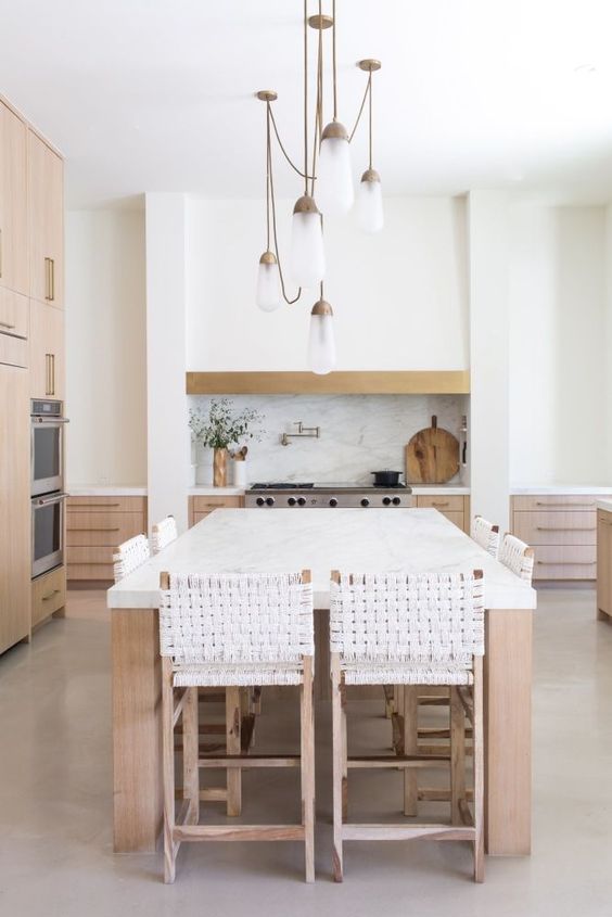 a welcoming contemporary kitchen with light-stained cabinets, a large kitchen island that doubles as a dining table