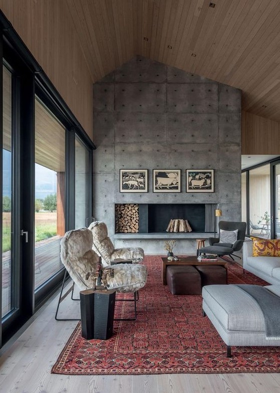 a welcoming modern living room with an oversized concrete fireplace, chic furniture and printed textiles is very cool