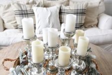 an arrangement of pillar candles in elegant metallic candle holders is a very chic and cool decoration for a winter space