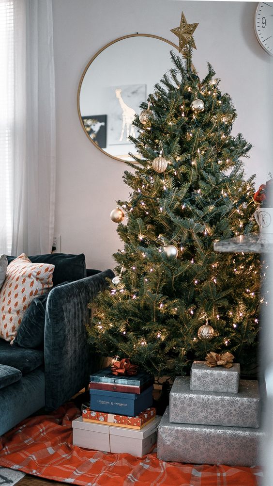 an elegant modern Christmas tree with gold and silver ornaments, lights and a gold star topper is a chic and beautiful decor idea