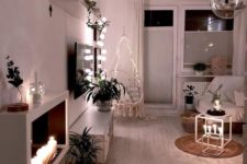 candles in candleholders and lanterns, lights over the chair and on the shelf make the space lit up and cozy