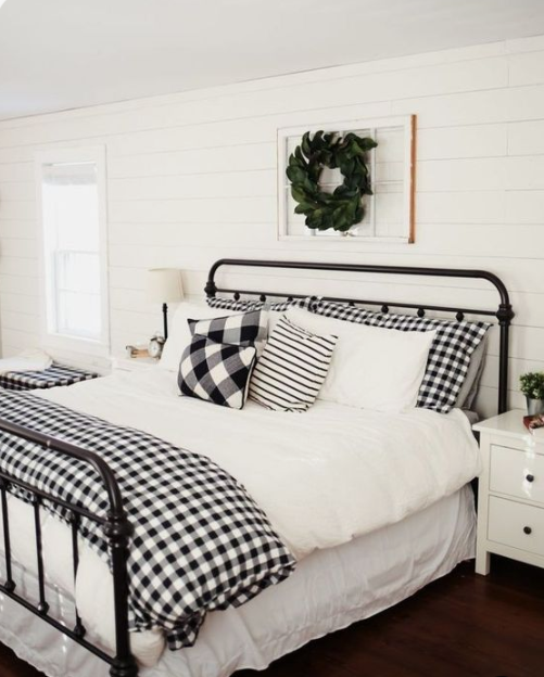 plaid bedding and a fresh greenery wreath over the bed make the bedroom clasically Christmassy