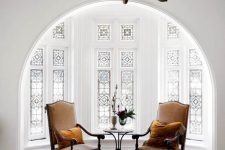 a beautiful alcove with a bay window with stained glass, a vintage table and carved chairs – this glass keeps privacy yet provides light