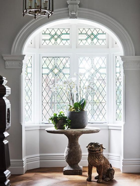 a beautiful bow window in a niche with lovely green stained glass is a gorgeous vintage decor feature for the space
