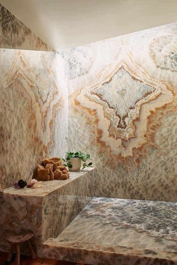 a beautiful shower space fully clad with gorgeous onyx and with a slab bench of it - you will need nothing else to feel in heaven
