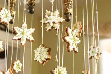 a chandelier decorated with glazed snowflake-shaped gingerbread cookies is a creative idea for a Christmas kitchen