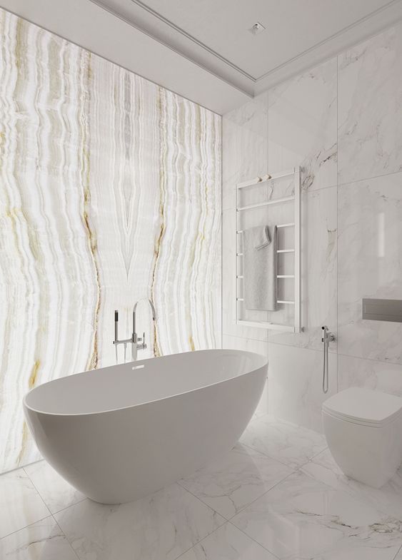 a contemporary white bathroom with white marble tiles and a single lit up onyx accent wall plus white appliances is wow