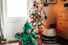 a flocked Christmas tree decorated with lights and pompom ornaments is a beautiful decoration you can provide for your kids